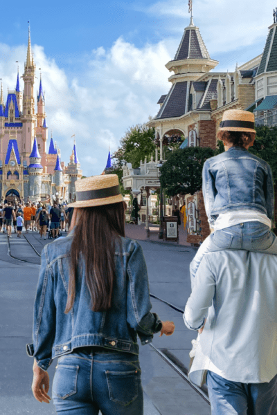 Disneyland Dad with child on his shoulders walking with wife through Disneyland